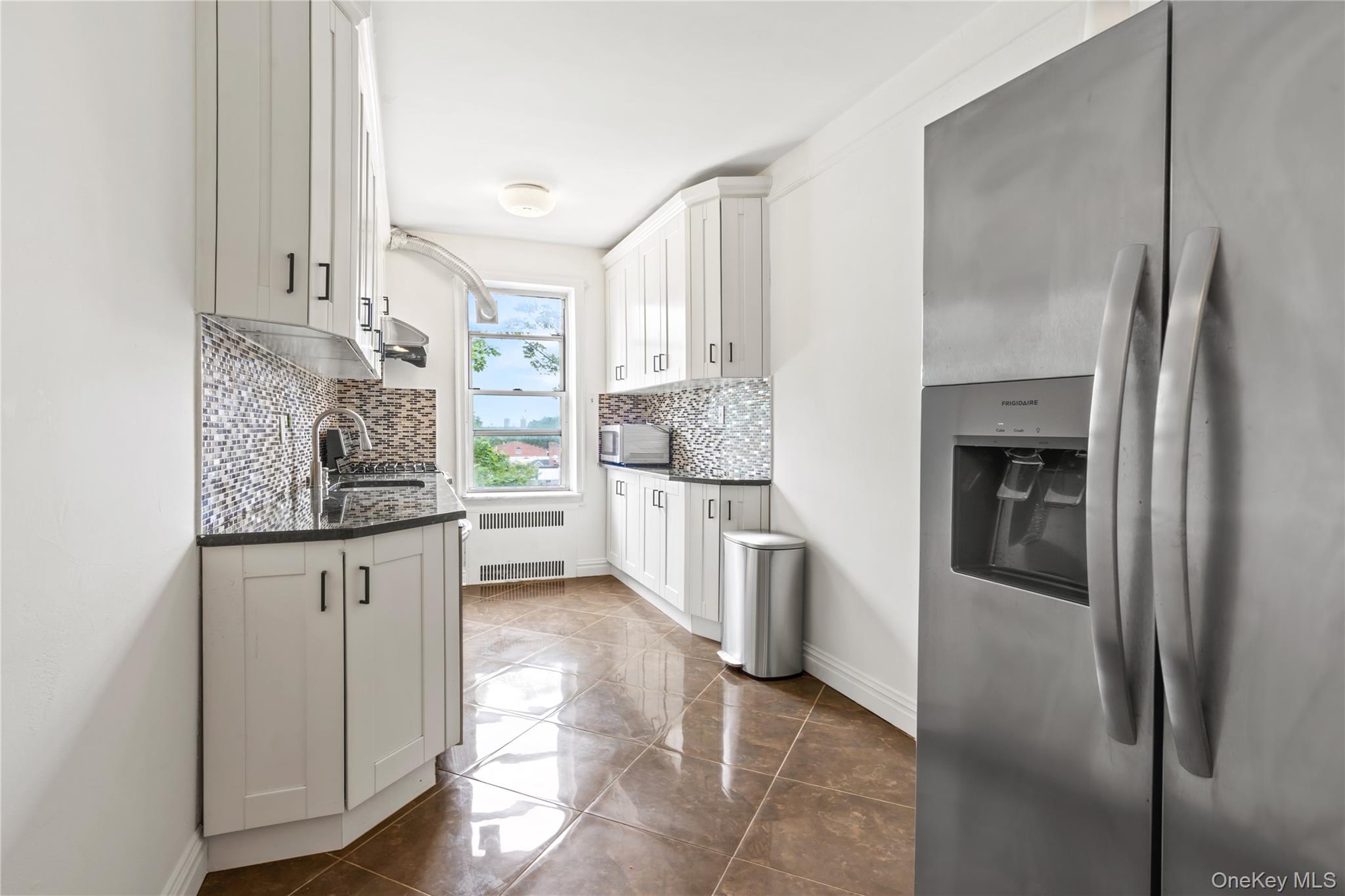 111-39 76th Road, Unit E7 Queens, NY 11375 - Photo 10 of 23 a kitchen with stainless steel appliances granite countertop a refrigerator and a stove