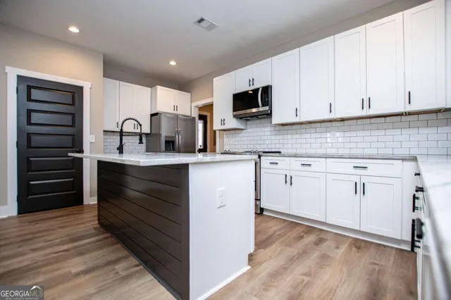a kitchen with cabinets appliances and a counter space