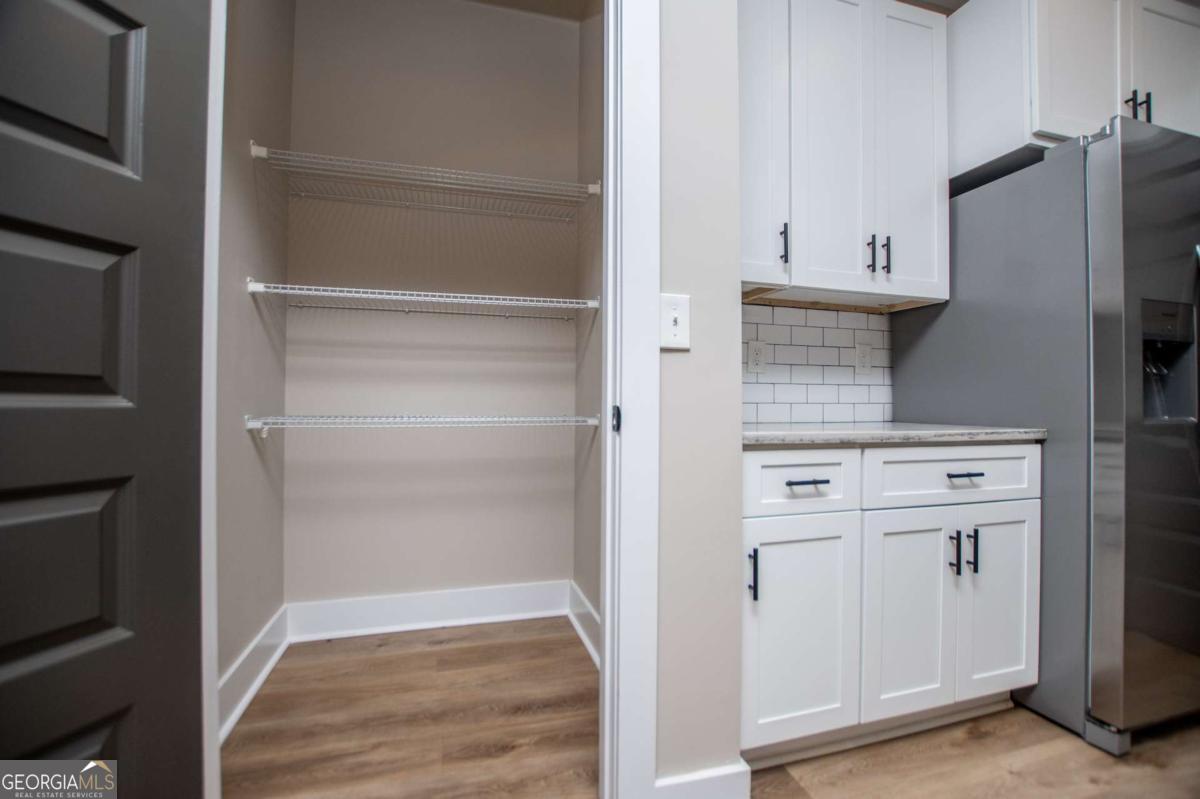 1605 5 Points Road Waco, GA 30182 - Photo 16 of 61 a kitchen with white cabinets and refrigerator