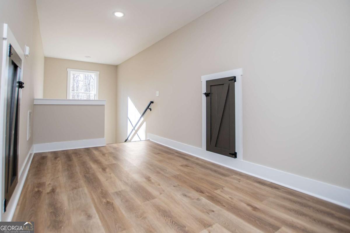 1605 5 Points Road Waco, GA 30182 - Photo 35 of 61 an empty room with wooden floor and windows