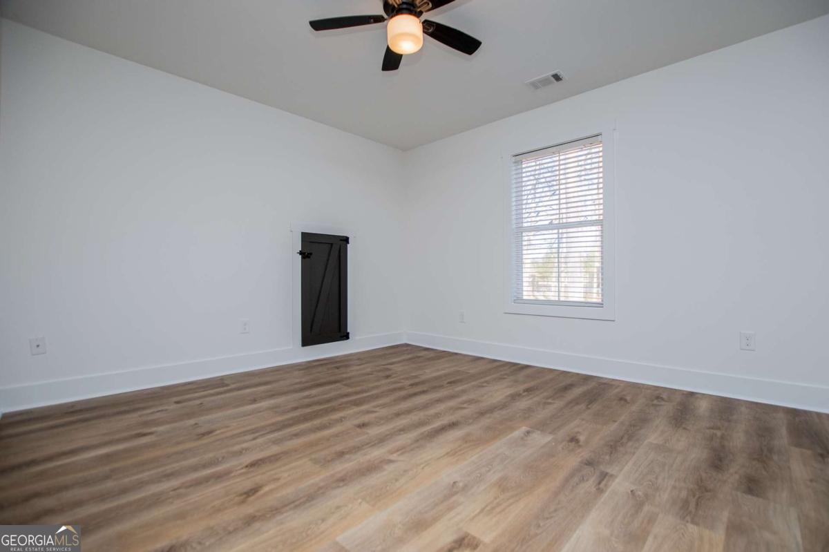 1605 5 Points Road Waco, GA 30182 - Photo 38 of 61 wooden floor in an empty room with a window