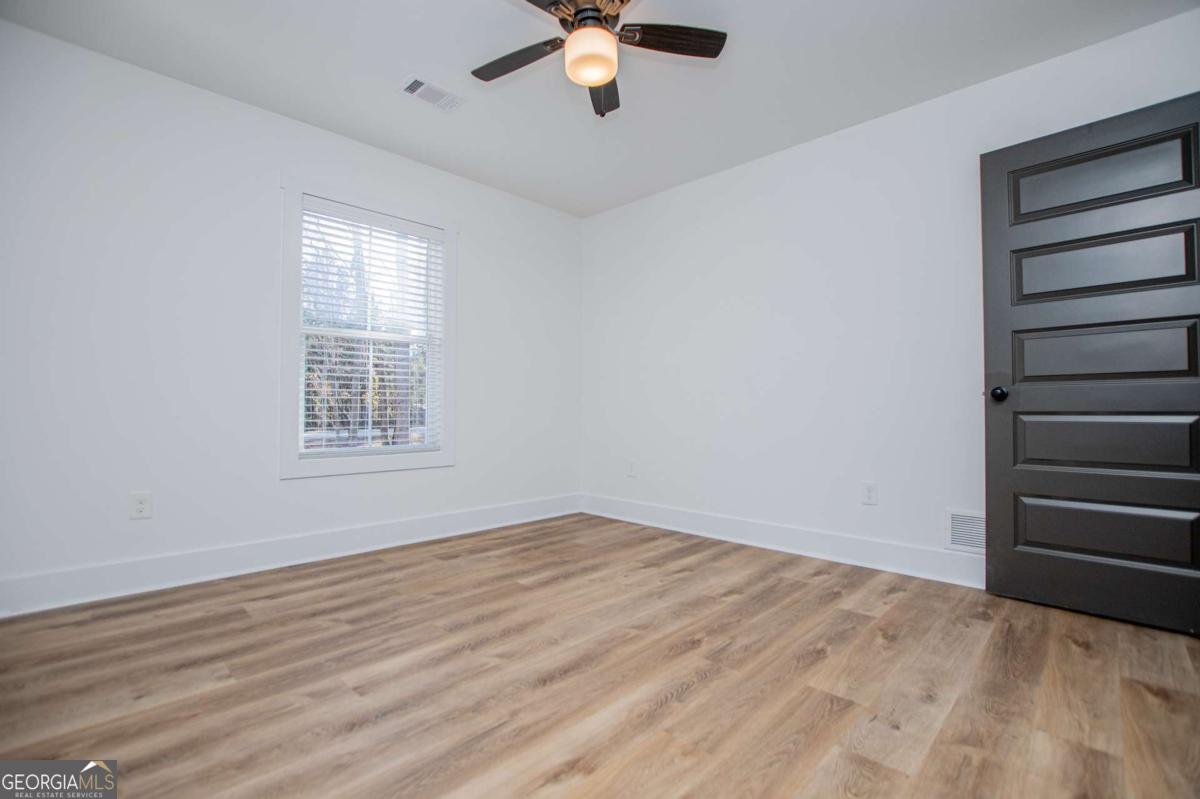 1605 5 Points Road Waco, GA 30182 - Photo 44 of 61 wooden floor in an empty room with a window