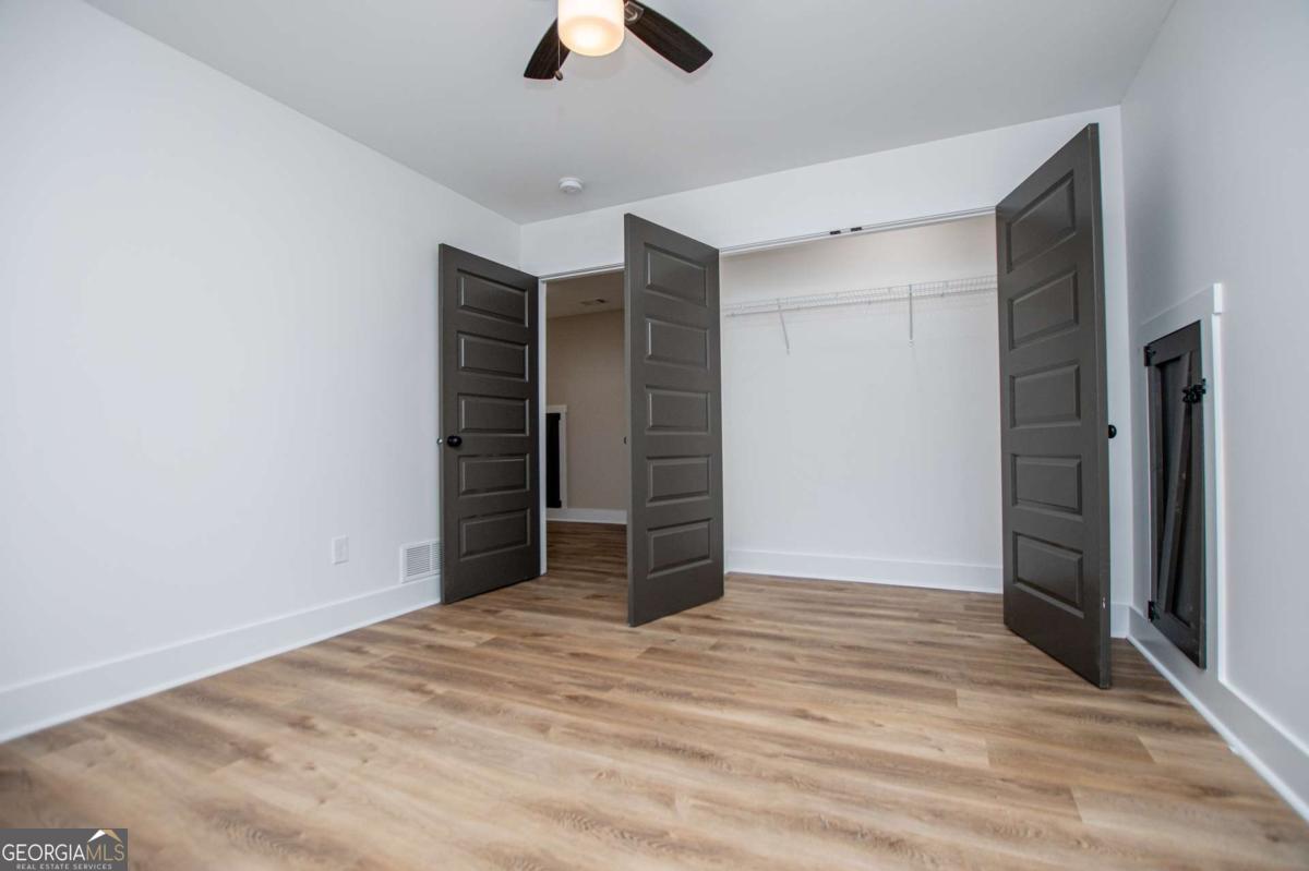 1605 5 Points Road Waco, GA 30182 - Photo 45 of 61 an empty room with closet and a ceiling fan