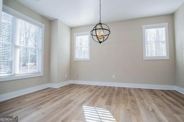 a view of empty room with window and chandelier