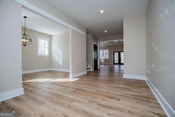 a view of a hallway with wooden floor and a living room