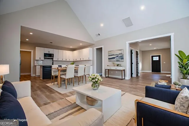 a living room with lots of furniture and kitchen view