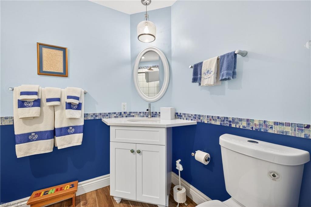 4030 Crayton Road, Unit C2 Naples, FL 34103 - Photo 28 of 32 a bathroom with a toilet a sink and a mirror