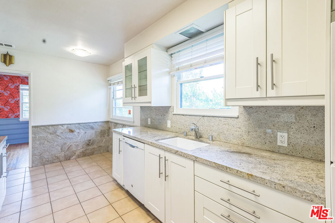 12753 Appleton Way Los Angeles, CA 90066 - Photo 7 of 31 a bathroom with a granite countertop sink a mirror and a bathtub
