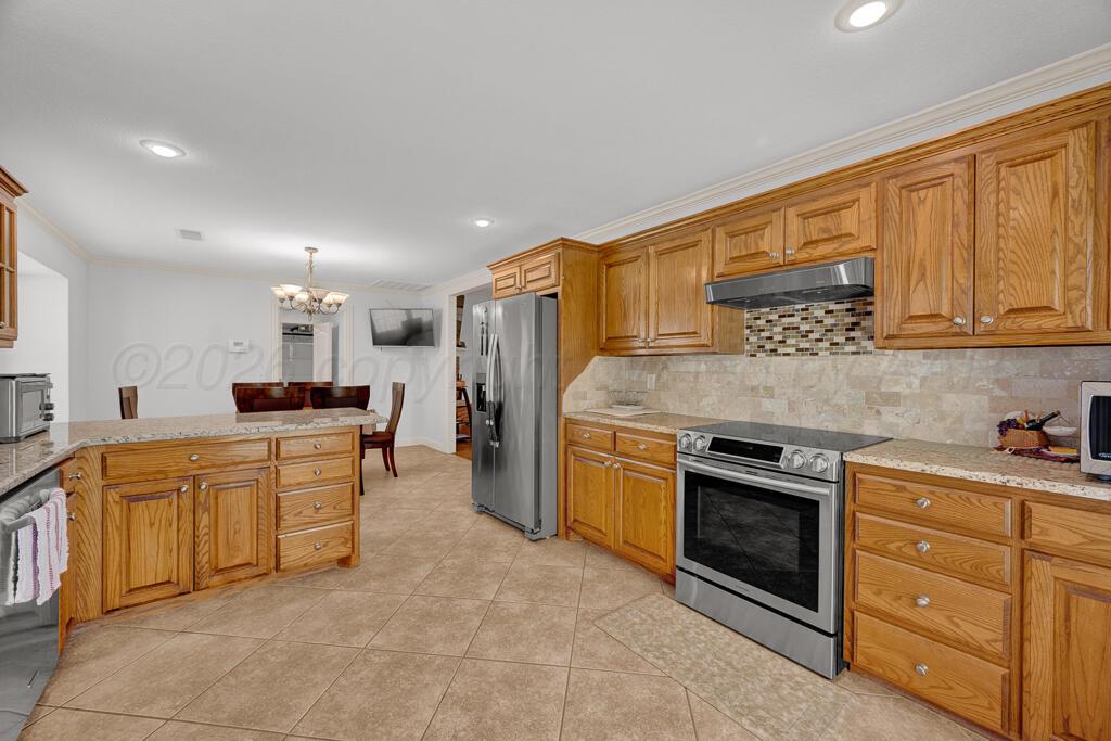 6604 Pepper Tree Place Amarillo, TX 79124 - Photo 6 of 28 a kitchen with stainless steel appliances granite countertop a stove top oven a sink dishwasher and a refrigerator with wooden cabinets