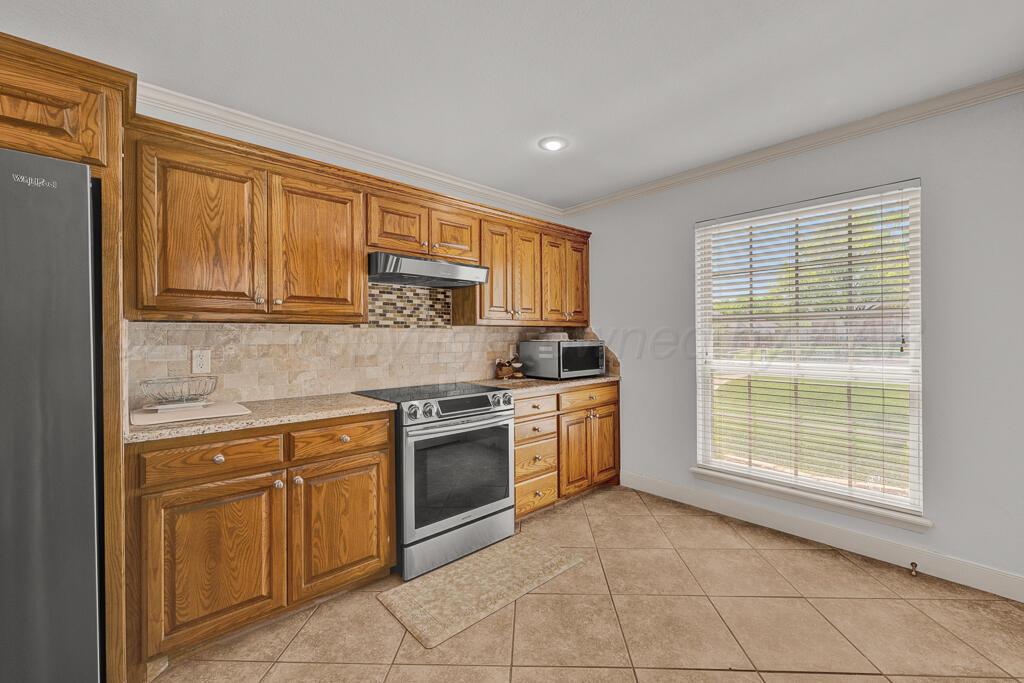 6604 Pepper Tree Place Amarillo, TX 79124 - Photo 9 of 28 a kitchen with stainless steel appliances granite countertop a stove a sink and a microwave