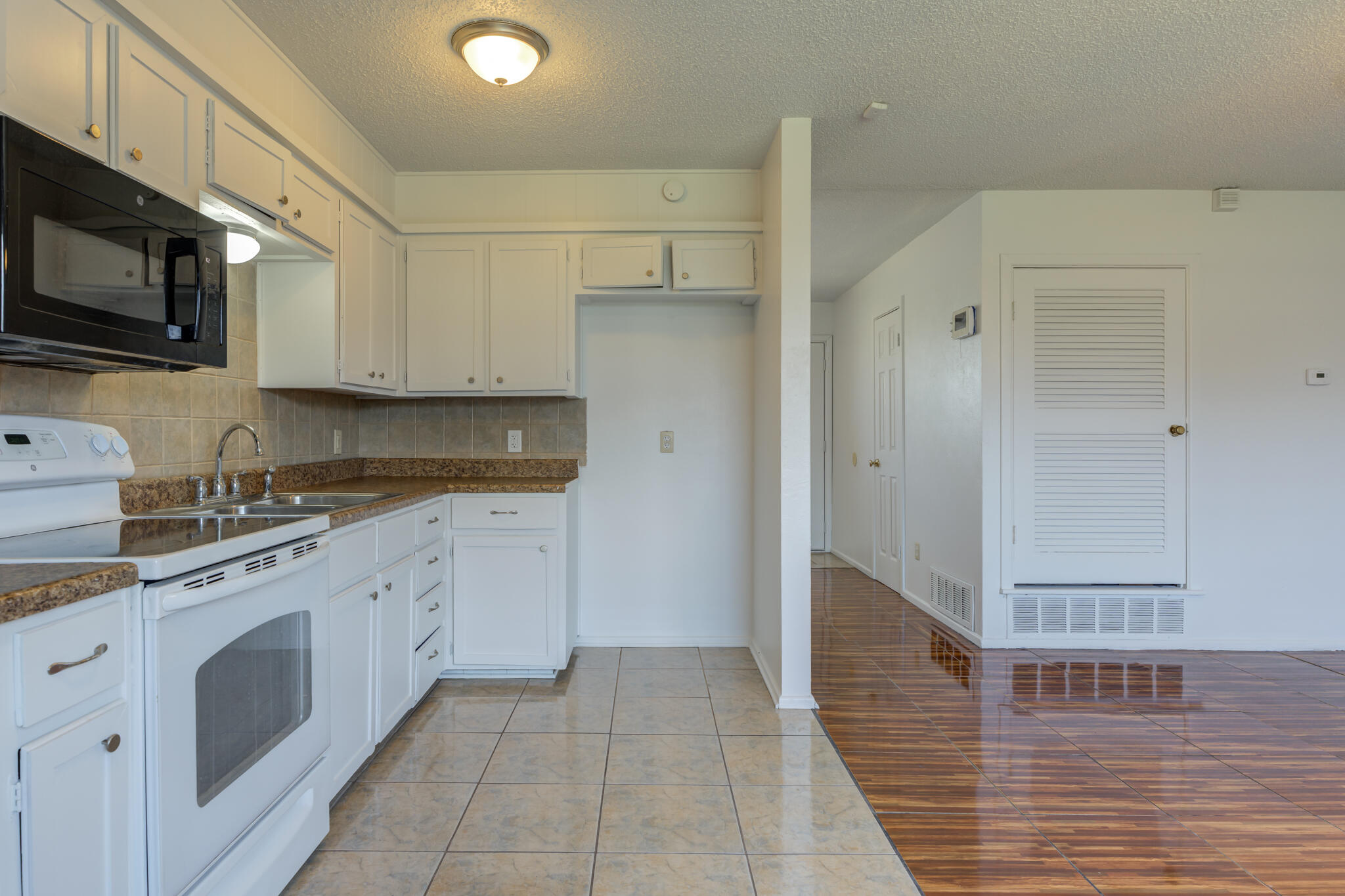 1313 Adrian Street Lubbock, TX 79403 - Photo 12 of 26 a kitchen with stainless steel appliances granite countertop a refrigerator and a stove top oven