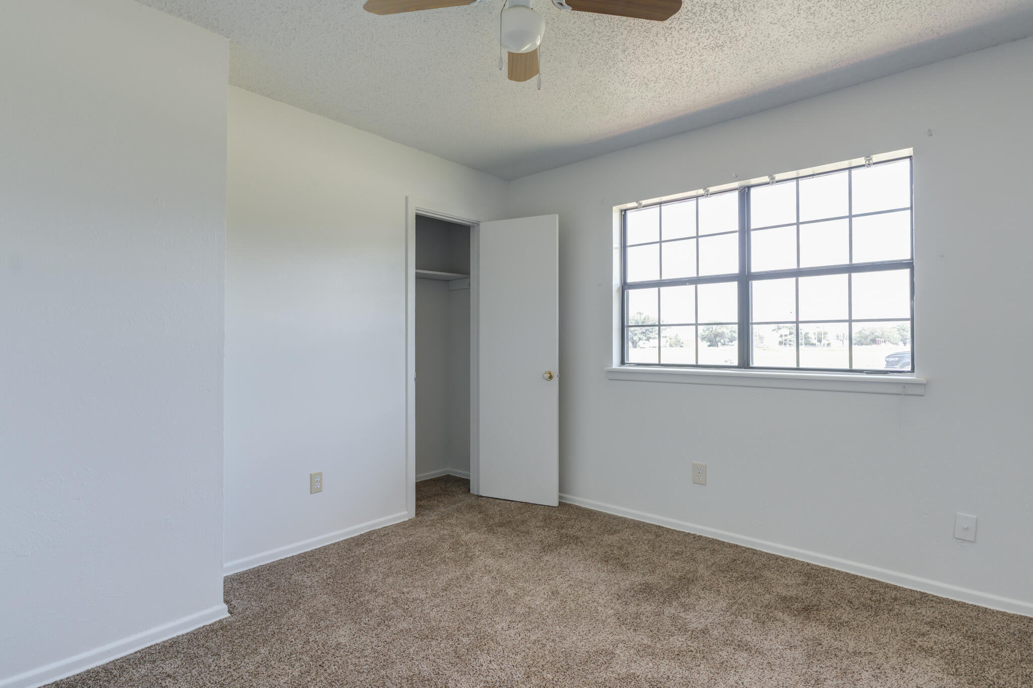 1313 Adrian Street Lubbock, TX 79403 - Photo 20 of 26 an empty room with windows and fan