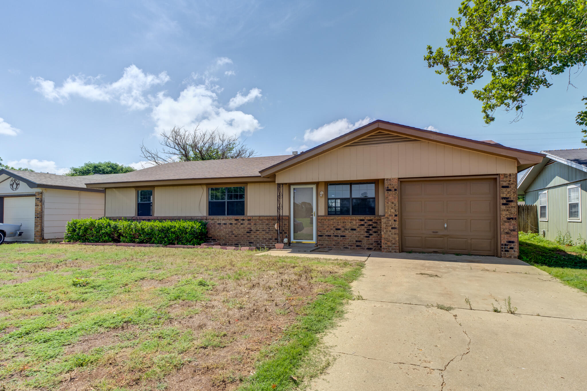 1313 Adrian Street Lubbock, TX 79403 - Photo 2 of 26 a front view of a house with a yard and garage
