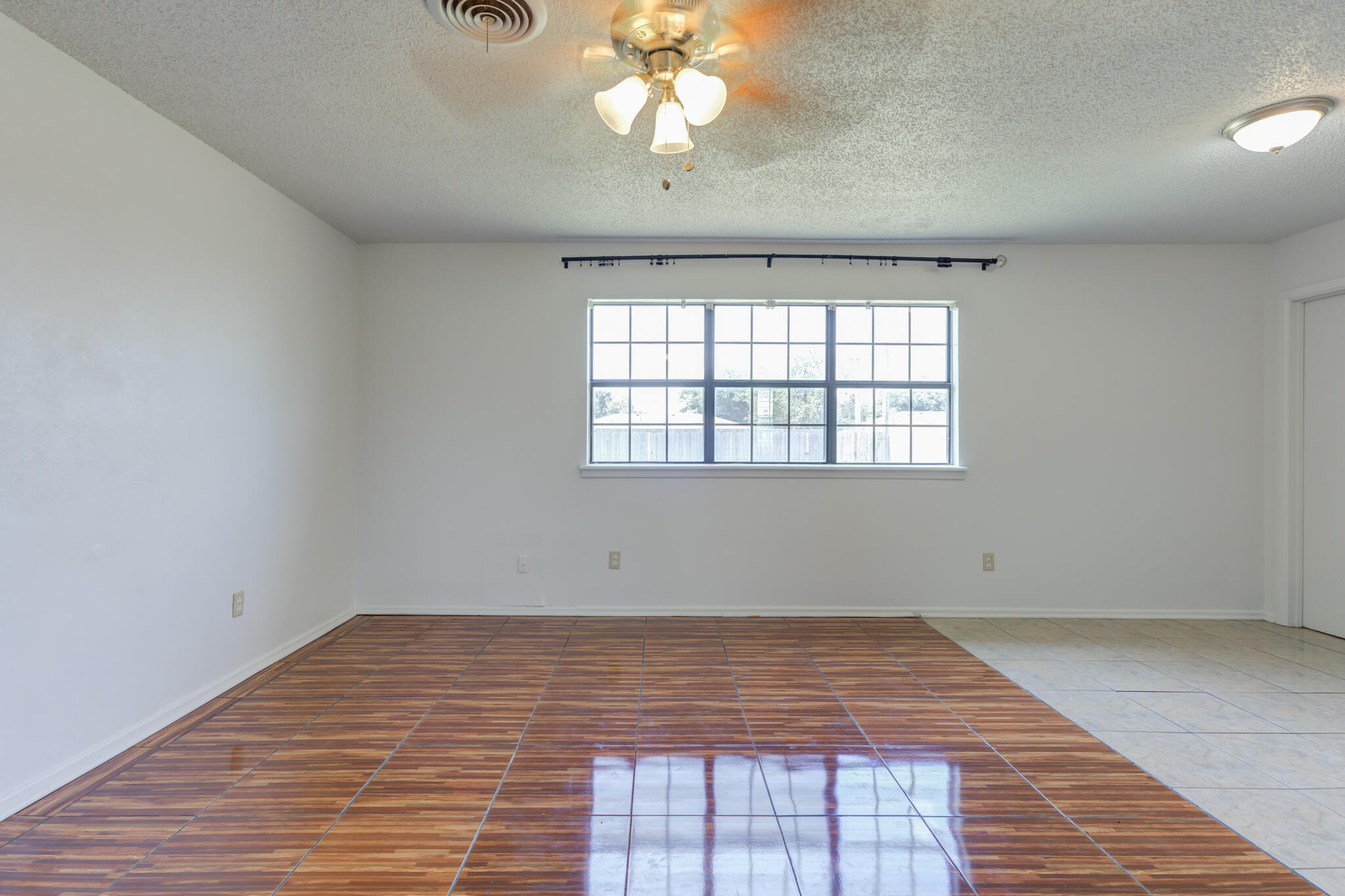 1313 Adrian Street Lubbock, TX 79403 - Photo 7 of 26 a view of empty room with wooden floor and fan