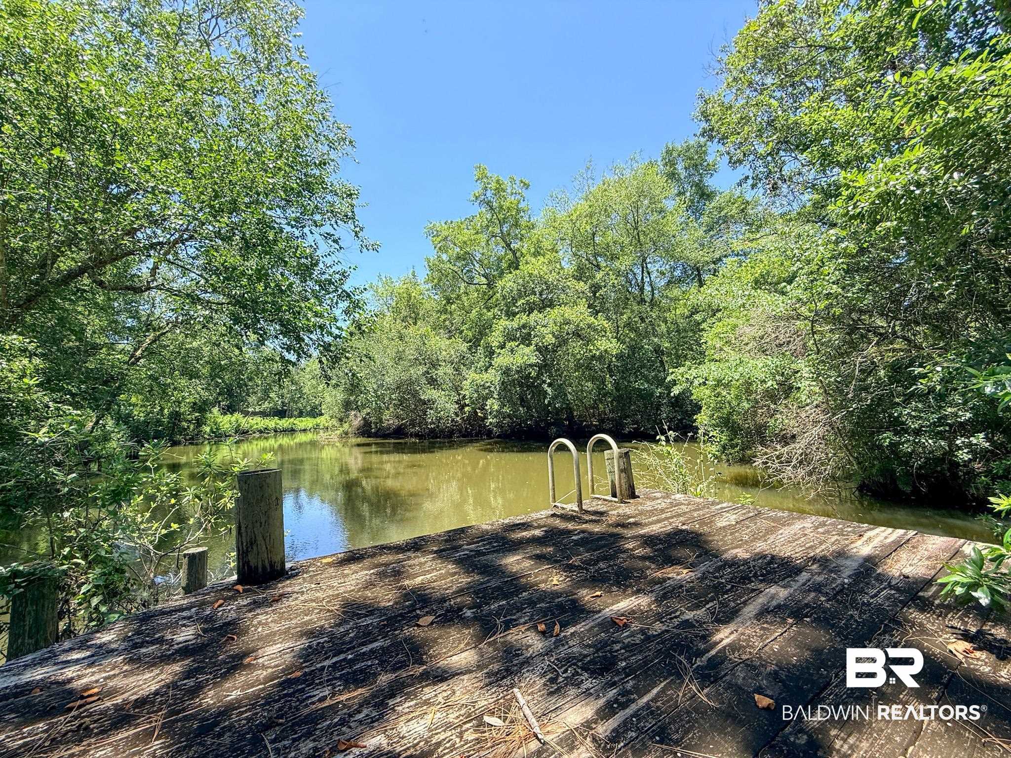 18711 Keller Road Foley, AL 36535 - Photo 31 of 38 Waterfront wood dock featuring a metal ladder and natural surroundings