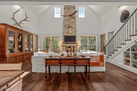 a living room with furniture a fireplace and a large window
