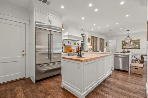 a kitchen with stainless steel appliances kitchen island granite countertop a refrigerator and a sink