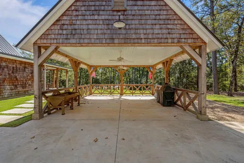 a view of a patio with table and chairs near a large tree