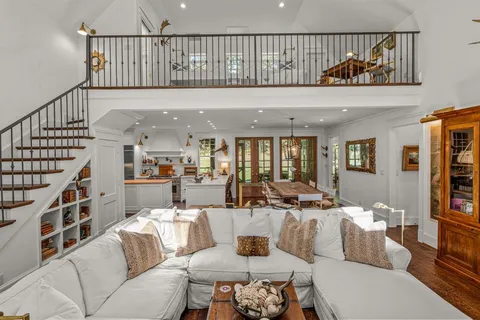 a living room with furniture stairs and a rug