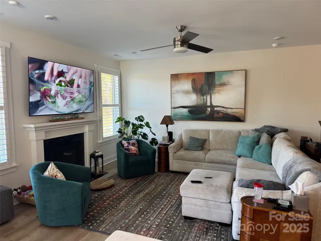 a living room with furniture a fireplace and a flat screen tv