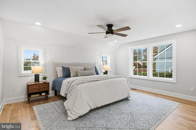 a spacious bedroom with a bed a rug and a large window