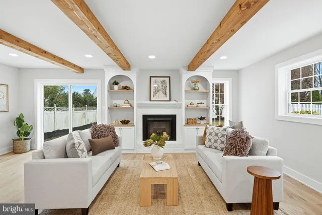 a living room with furniture fireplace and a large window