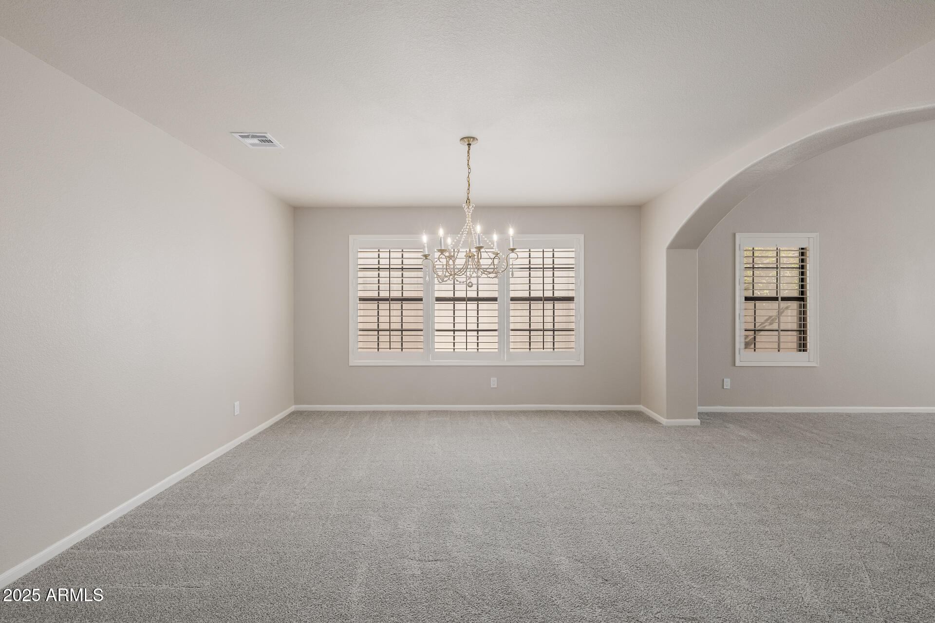 16809 South 33rd Way Phoenix, AZ 85048 - Photo 23 of 118 an empty room with windows and chandelier