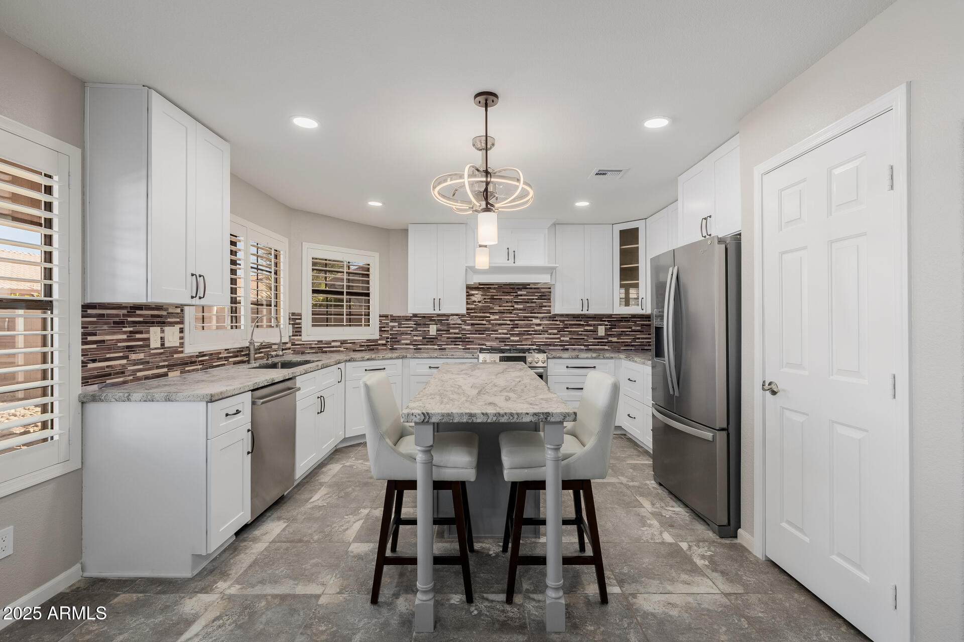 16809 South 33rd Way Phoenix, AZ 85048 - Photo 38 of 118 a kitchen with stainless steel appliances granite countertop a dining table chairs refrigerator and sink
