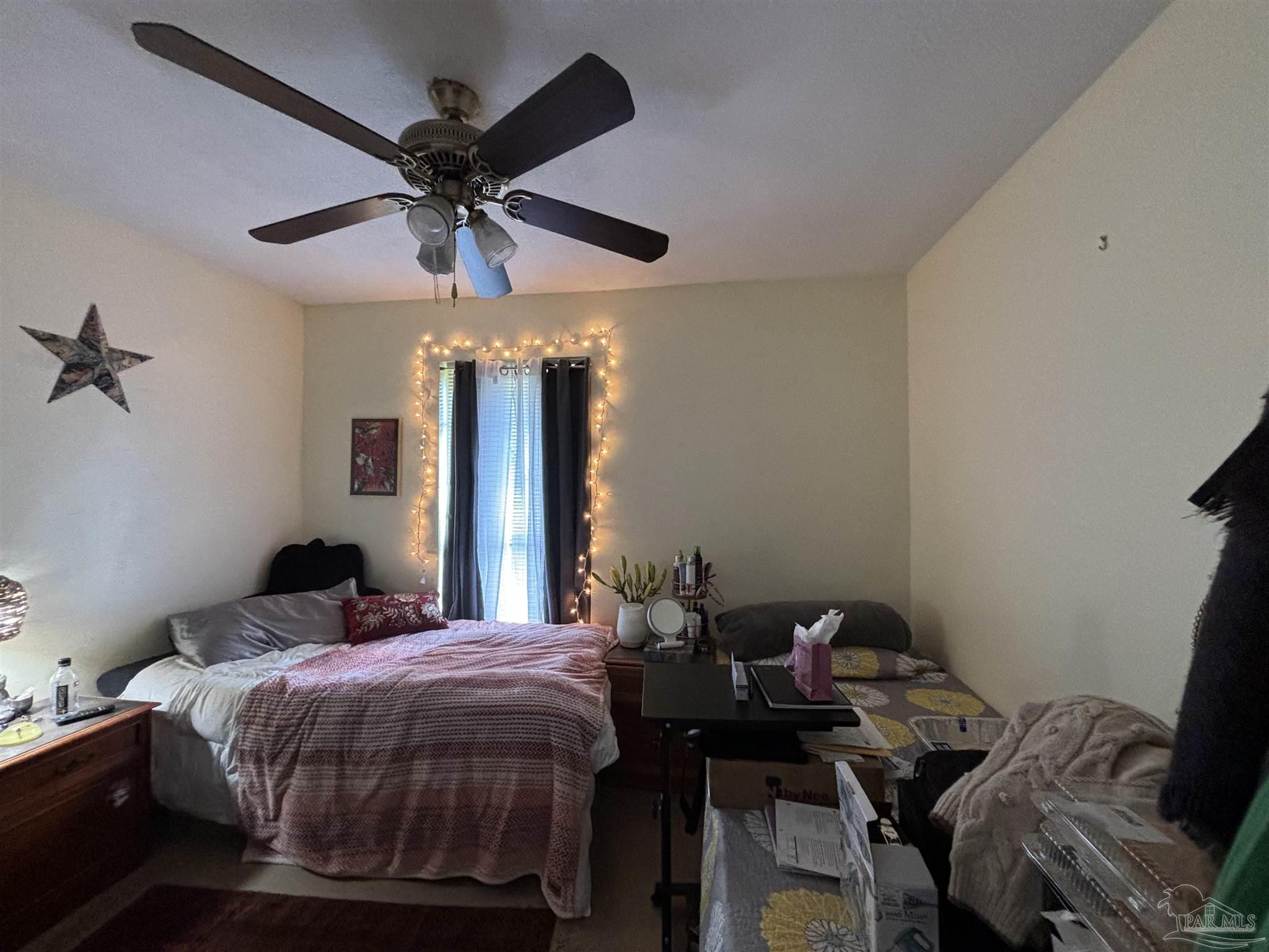 1080 Farmington Road Pensacola, FL 32504 - Photo 11 of 31 a bedroom with a bed and a chandelier