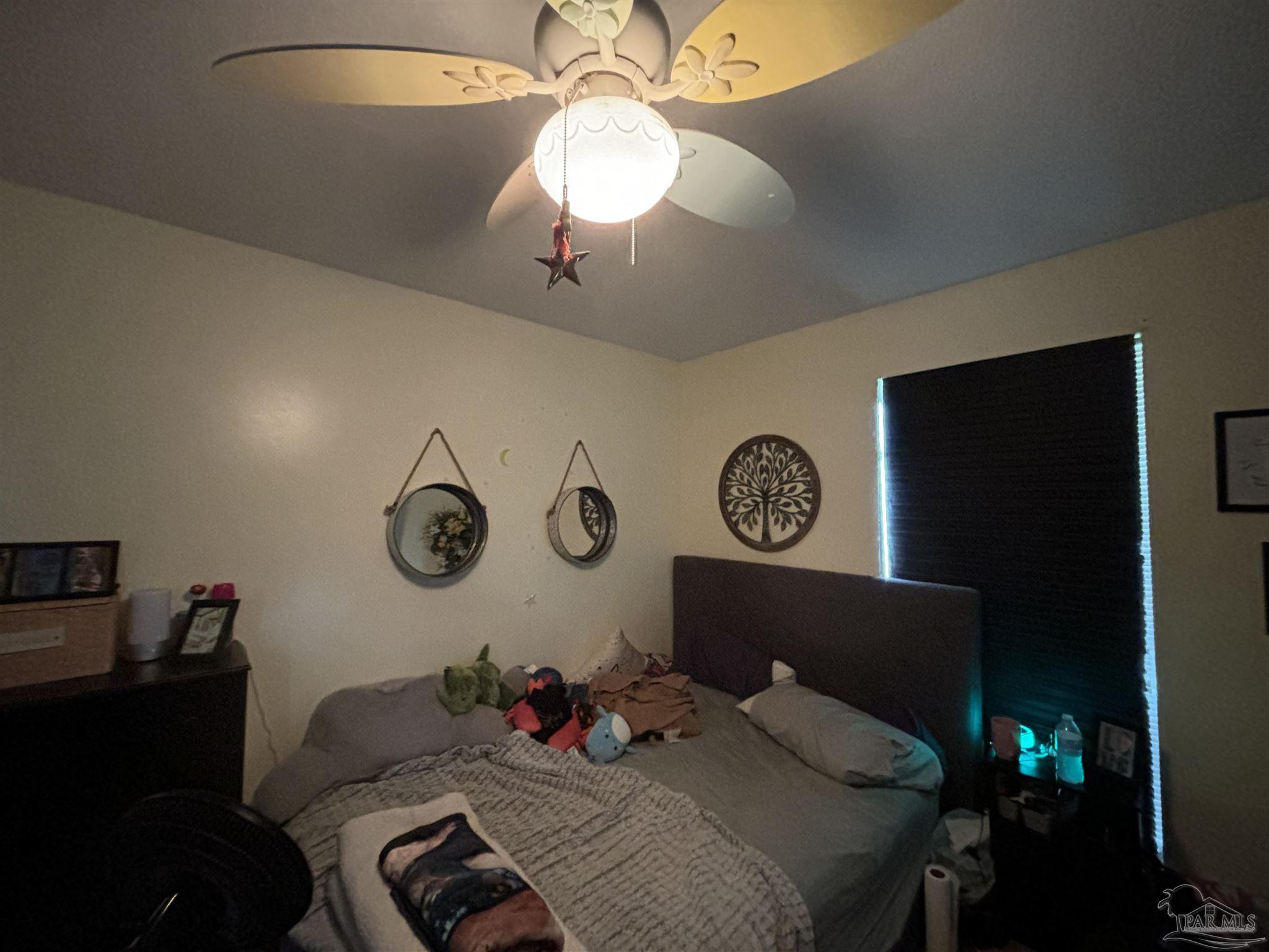 1080 Farmington Road Pensacola, FL 32504 - Photo 13 of 31 a bedroom with a bed and a chandelier