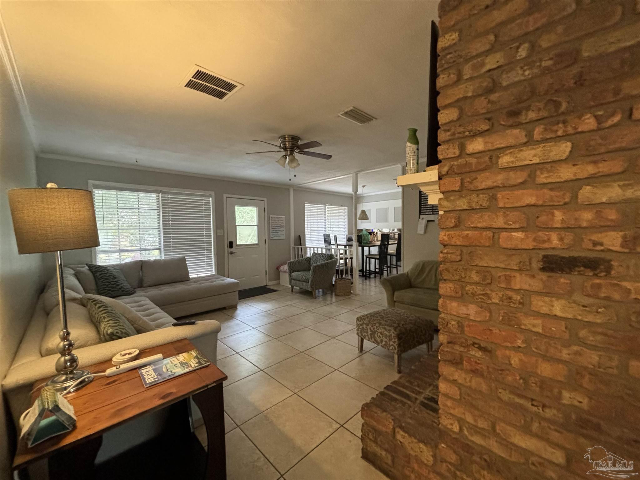 1080 Farmington Road Pensacola, FL 32504 - Photo 3 of 31 a living room with couches and a flat screen tv with kitchen view