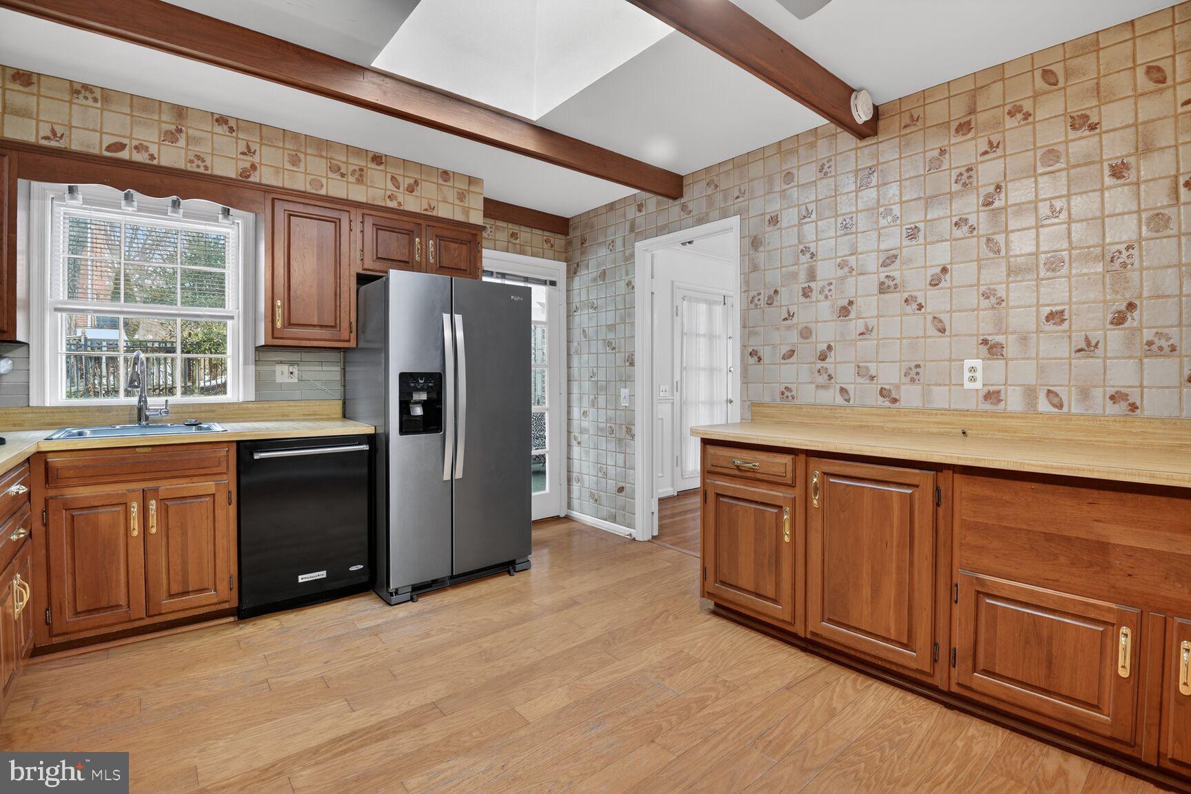 4709 River Road Bethesda, MD 20816 - Photo 13 of 25 a kitchen with stainless steel appliances granite countertop a refrigerator and wooden cabinets