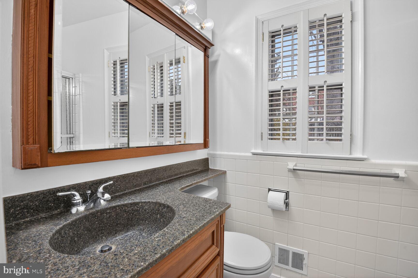 4709 River Road Bethesda, MD 20816 - Photo 19 of 25 a bathroom with a granite countertop sink and a toilet