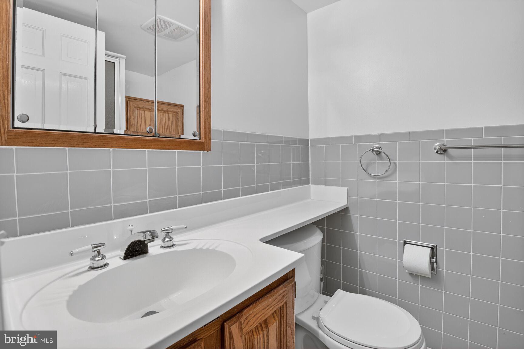 4709 River Road Bethesda, MD 20816 - Photo 21 of 25 a bathroom with a sink toilet and mirror