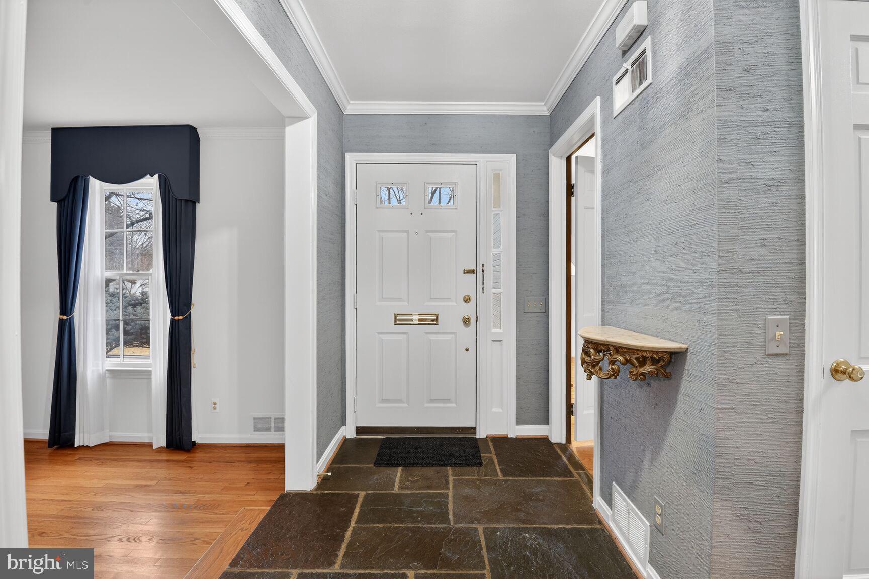 4709 River Road Bethesda, MD 20816 - Photo 5 of 25 a view of a hallway with wooden floor and a bathroom