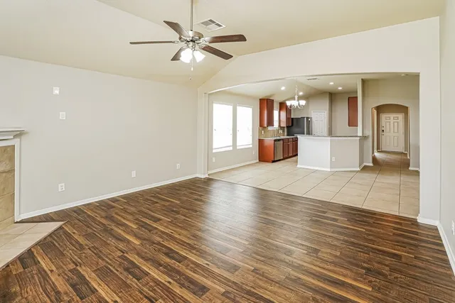 wooden floor in an empty room with a kitchen