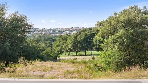 a aerial view of multi story residential apartment building with swimming pool and lawn chairs