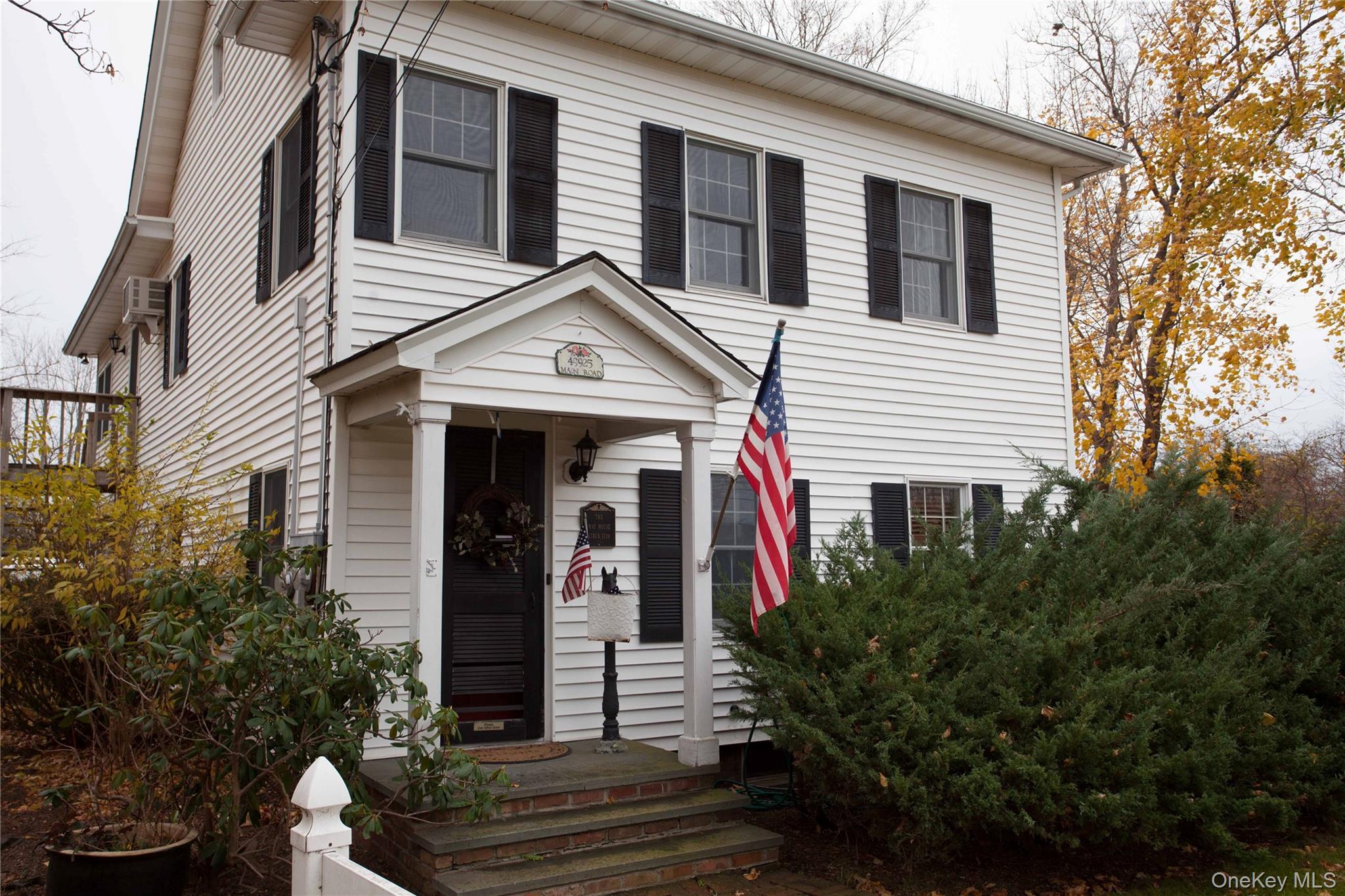 View of front facade with a wall mounted air conditioner