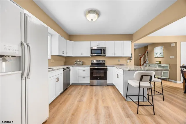 a kitchen with granite countertop a sink cabinets and stainless steel appliances