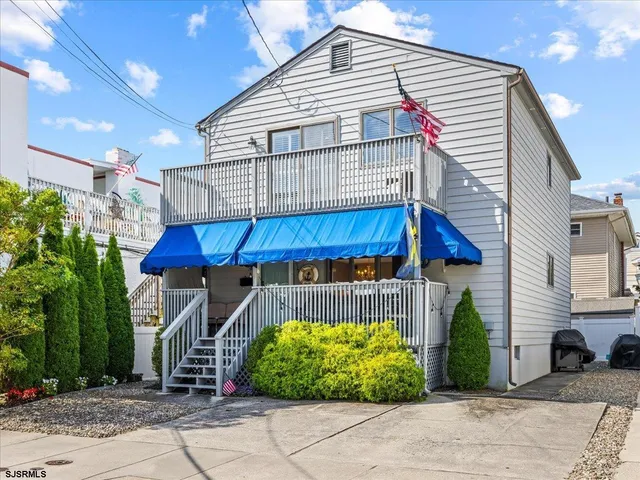 a view of a house with a patio and a yard