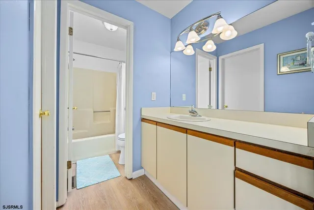 a bathroom with a granite countertop sink a mirror and a bathtub