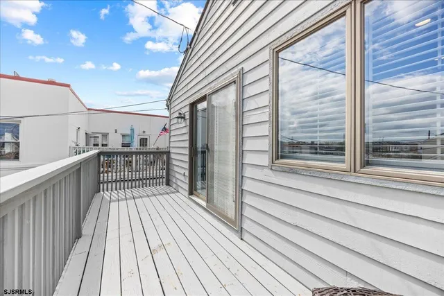 a view of a balcony with wooden floor and fence