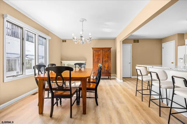 a dining room with furniture a chandelier and wooden floor