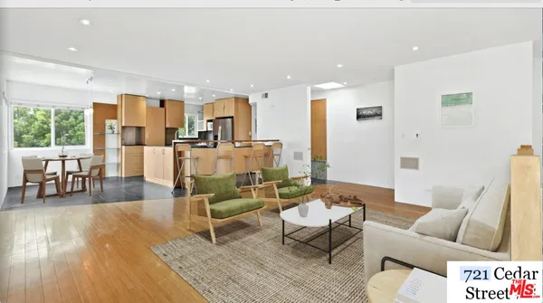 a living room with furniture and large wooden floor