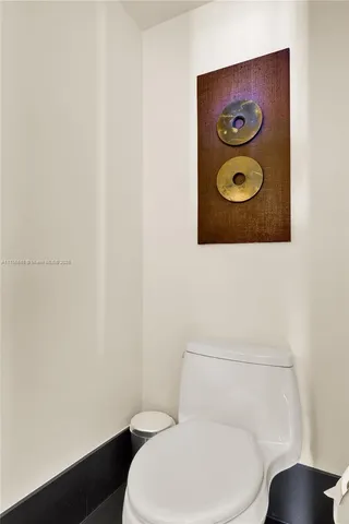 a white toilet sitting next to a wooden wall