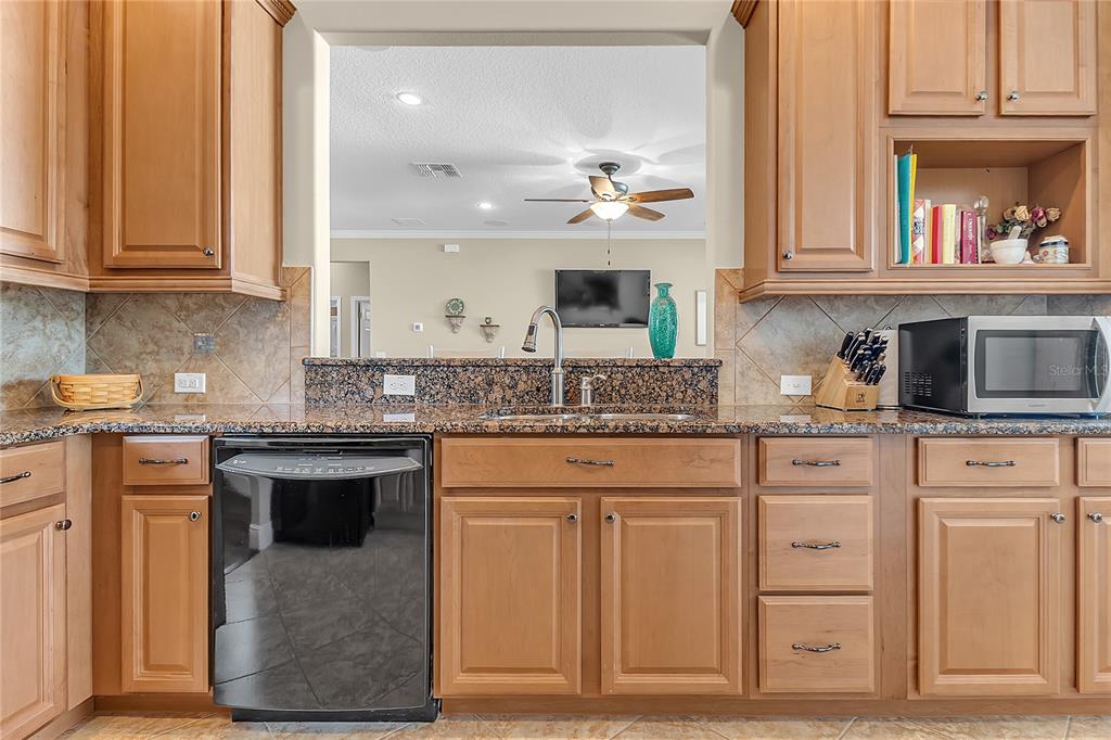 877 Strathmore Drive Orlando, FL 32803 - Photo 15 of 38 a kitchen with stainless steel appliances granite countertop a sink and cabinets with wooden floor