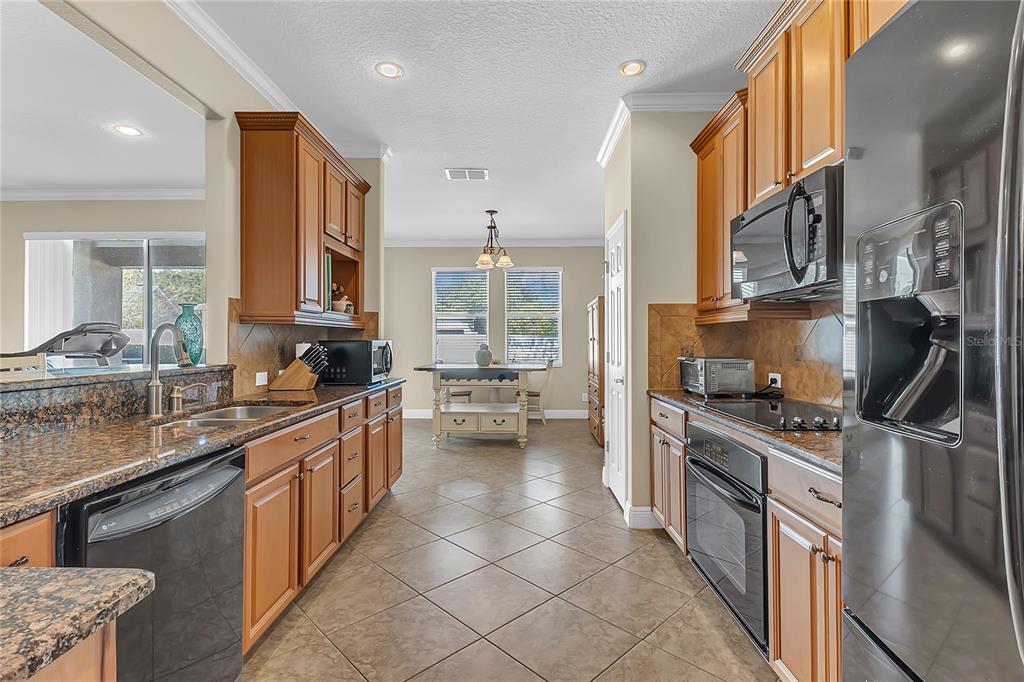 877 Strathmore Drive Orlando, FL 32803 - Photo 17 of 38 a kitchen with stainless steel appliances granite countertop a stove a sink and a refrigerator