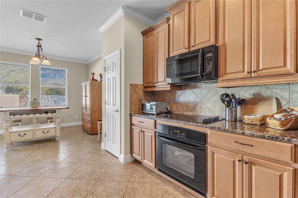 877 Strathmore Drive Orlando, FL 32803 - Photo 2 of 38 a kitchen with stainless steel appliances granite countertop a stove a sink and a microwave