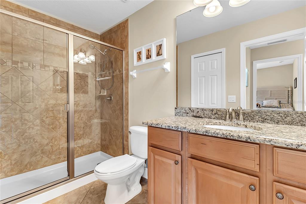 877 Strathmore Drive Orlando, FL 32803 - Photo 28 of 38 a bathroom with a granite countertop sink toilet and shower