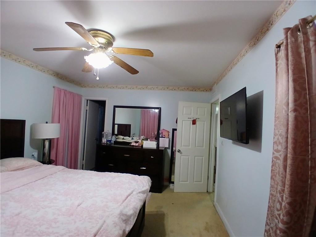 242 Lake Jodeco Road, Unit 242 Jonesboro, GA 30236 - Photo 36 of 45 a bedroom with a bed and a flat tv screen on dresser